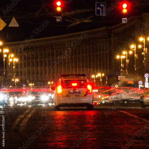 Car in the middle of a night city. Police car in the center of night Kiev. © mischenko