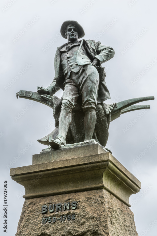 Sydney, Australia - March 23, 2017: Closeup of figure on top of pedestal, an all bronze statue of Robert Burns on side of Vernon building of Art Gallery of NSW. Against silver sky.
