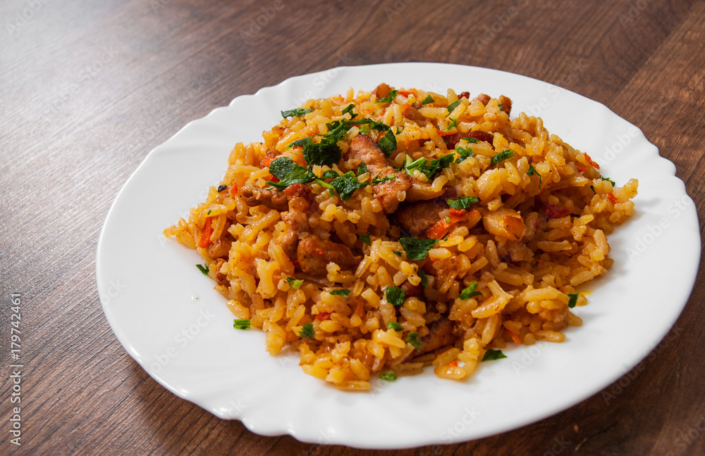 Rice with Vegetables and Meat in a plate on wooden table. Rice with Vegetables and Meat in a plate on wooden table.