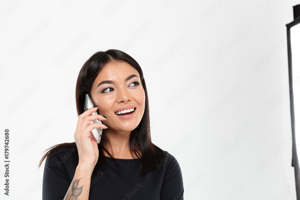 Happy young asian lady talking by mobile phone. Looking aside. Happy young asian lady talking by mobile phone. Looking aside.