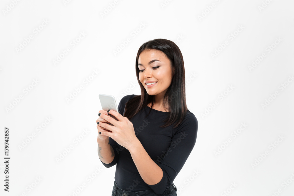 Smiling young asian lady chatting by mobile phone