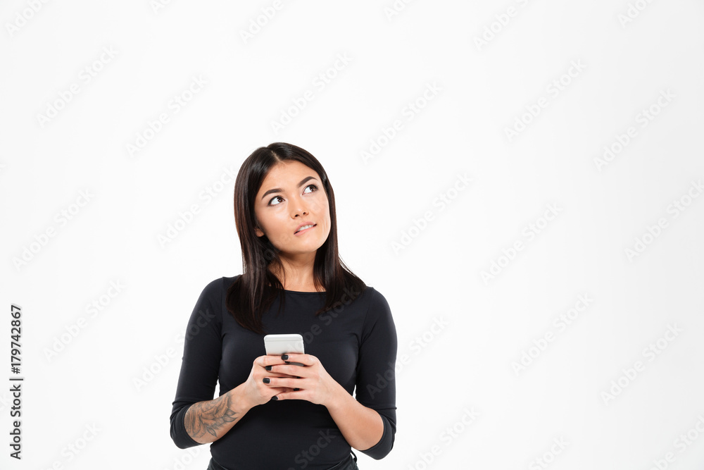 Thoughtful young asian woman chatting by mobile phone Thoughtful young asian woman chatting by mobile phone