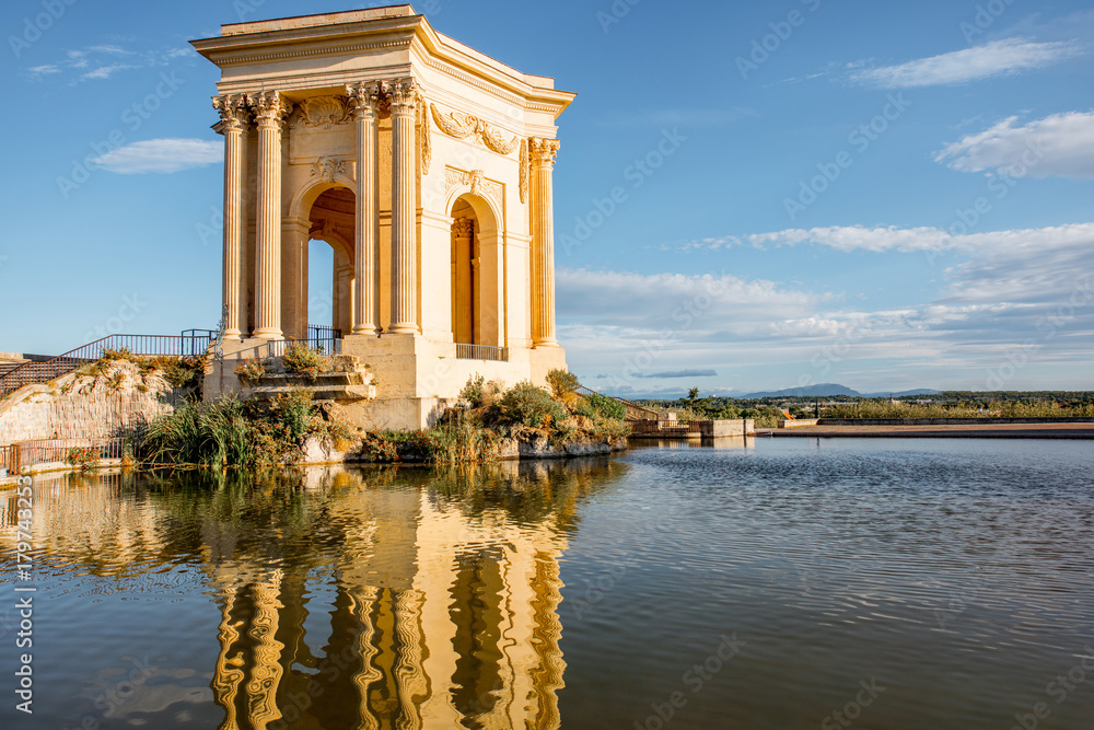 View on the water tower in Peyrou garden with beautiful water reflection during the morning light in Montpellier city in southern France View on the water tower in Peyrou garden with beautiful water reflection during the morning light in Montpellier city in southern France