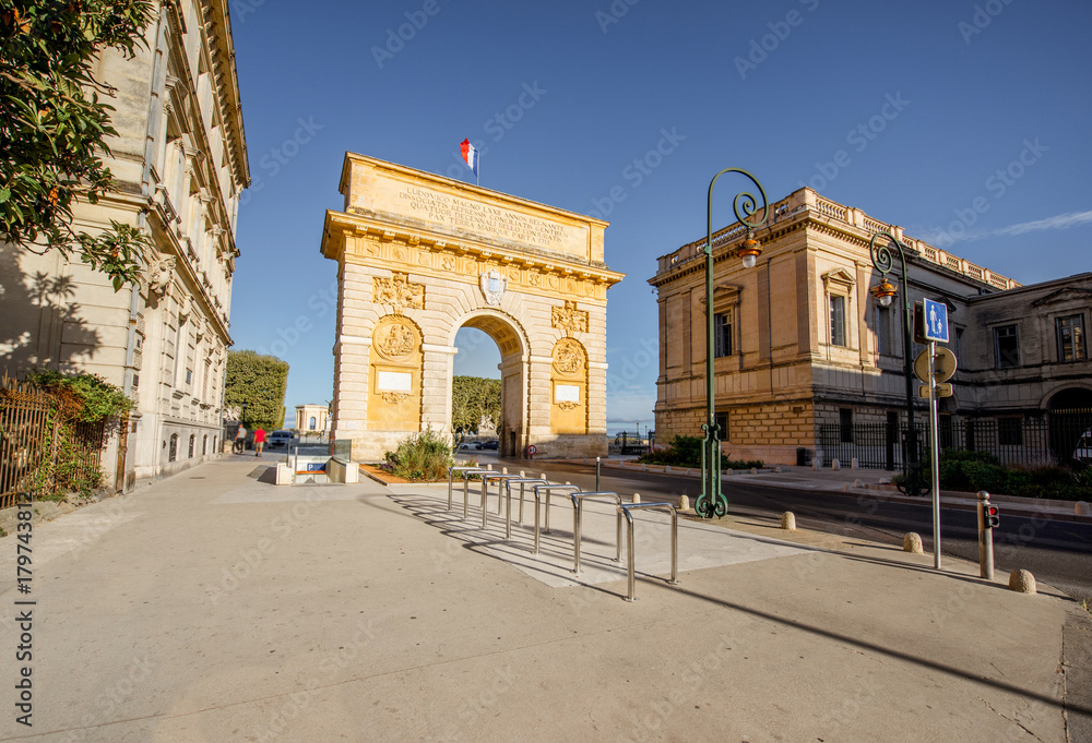 Street view with famous Triumphal Arch on the Foch boulevard during the morning light in Montpellier city in Occitanie region of France