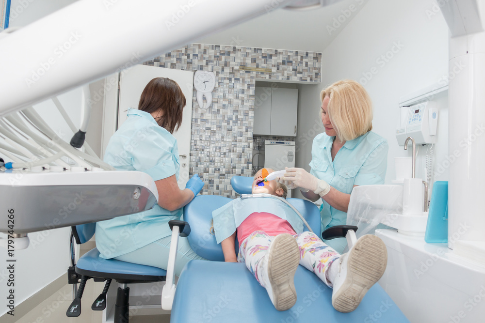 Fototapeta premium Little girl sitting in the dentists office