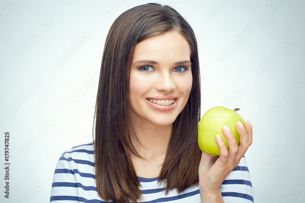 Girl smile with teeth and toothy braces holding green apple Girl smile with teeth and toothy braces holding green apple
