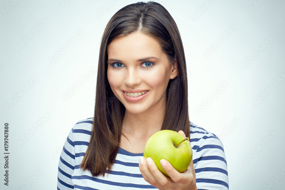 Girl smile with teeth and toothy braces holding green apple Girl smile with teeth and toothy braces holding green apple