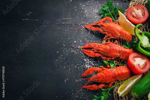 Lobster and fresh vegetables. Seafood. On a wooden background. Top view. Free space for your text.