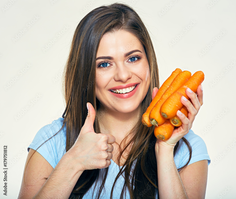 Smiling woman holding carrot giving thumb up Smiling woman holding carrot giving thumb up
