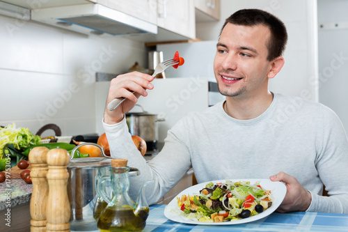 Ordinary  handsome man holding plate with salad