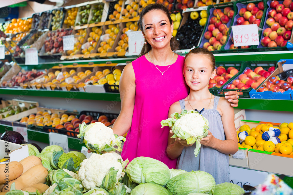 woman with girl buying cabbage
