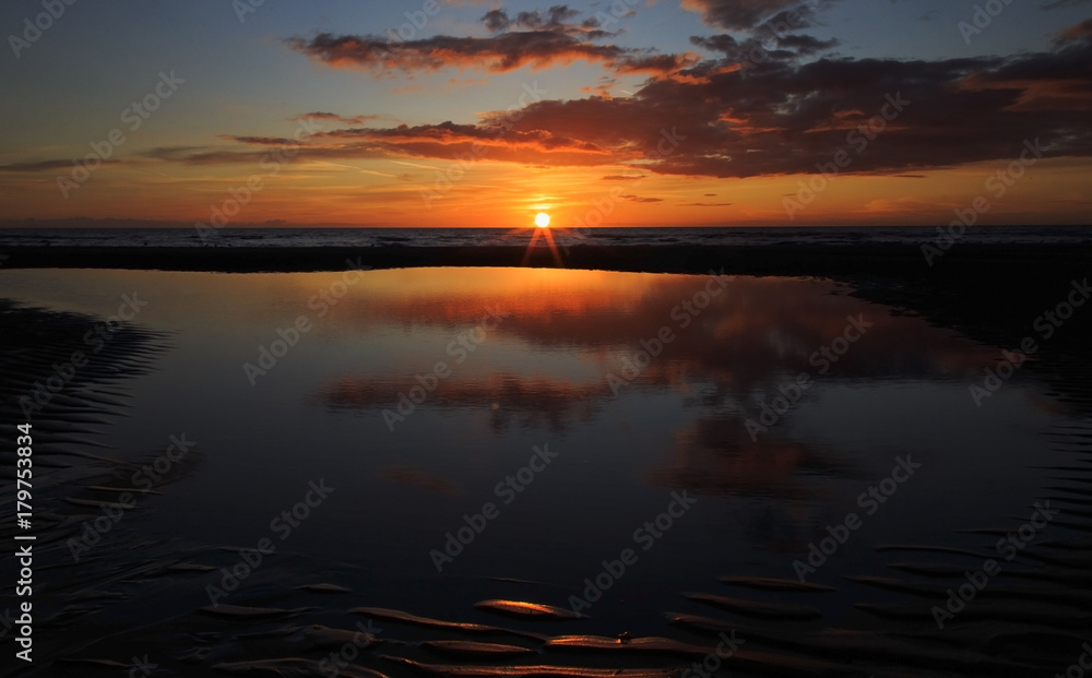 Sunset reflected in beach pool on Blackpool beach