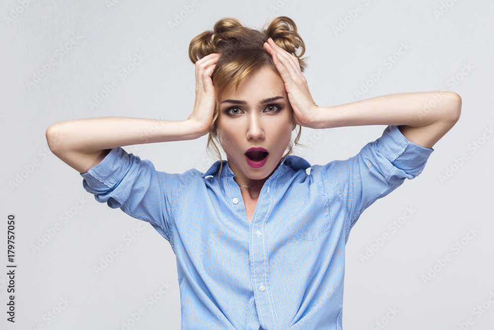 Blonde woman screaming with shock, holding hands on her head. Blonde woman screaming with shock, holding hands on her head.