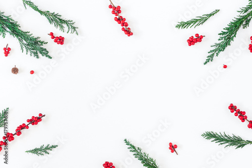 Christmas composition. Frame made of christmas tree branches and red berries on white background. Flat lay, top view, copy space