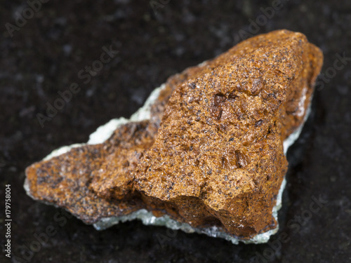 raw bog iron ore ( limonite) stone on dark