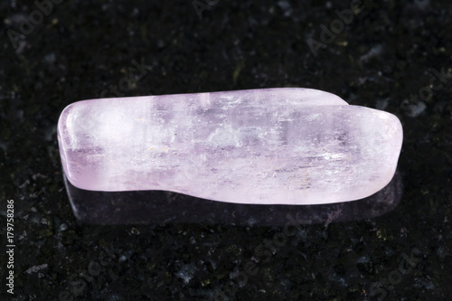 polished kunzite gemstone on dark background photo