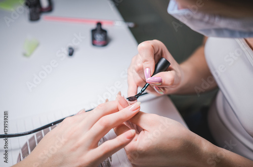 Manicurist hand painting client s nails