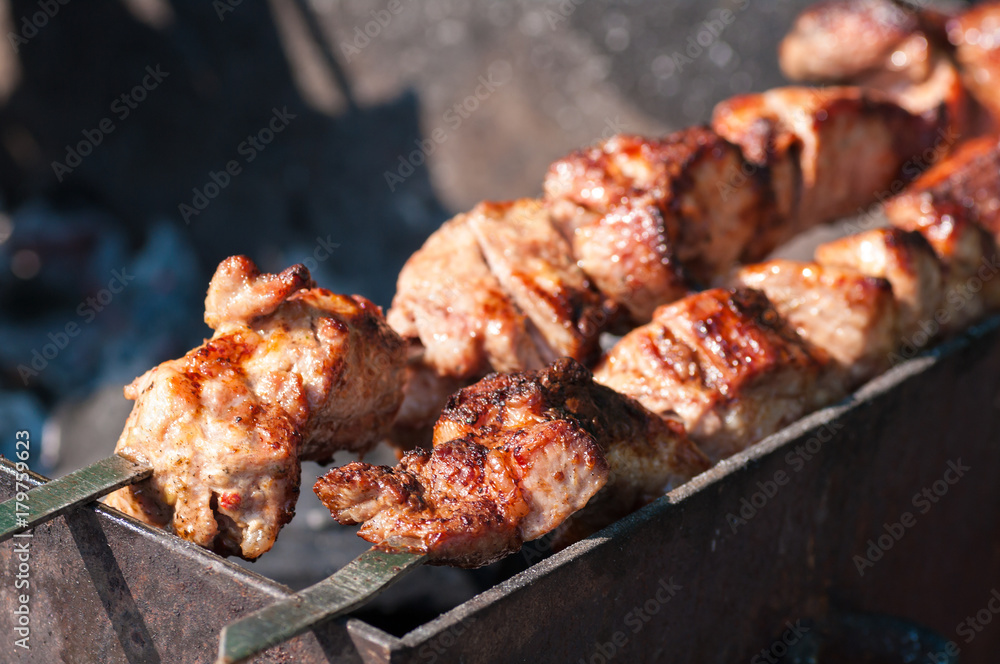skewers fried meat on a grill
