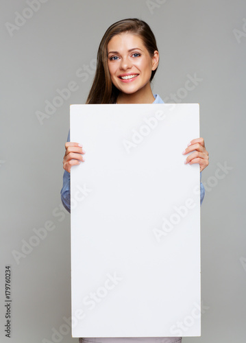 woman holding white big sign board against gray wall.