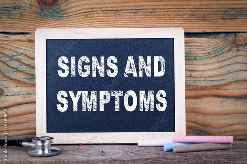 signs and symptoms. Chalkboard on a wooden background. photo