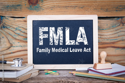 fmla, family medical leave act. Chalkboard on a wooden background. photo