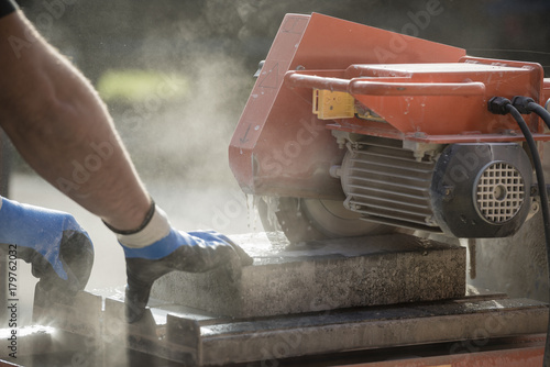 Workman cutting using an angle grinder