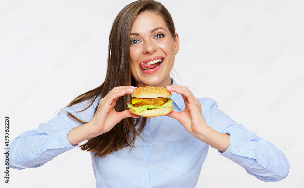 Smiling woman holding burger licking lips. Smiling woman holding burger licking lips.