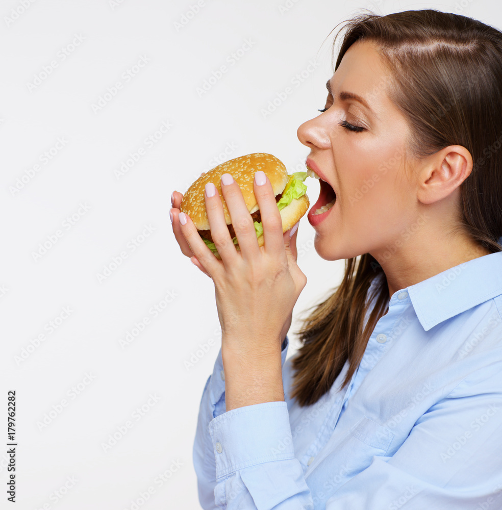 Portrait of young woman eating fast food burger. Portrait of young woman eating fast food burger.