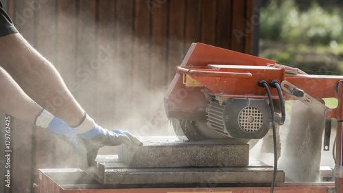 Side view of a man using an angle grinder