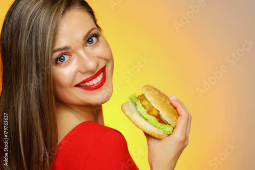 Close up face portrait of woman eating burger.