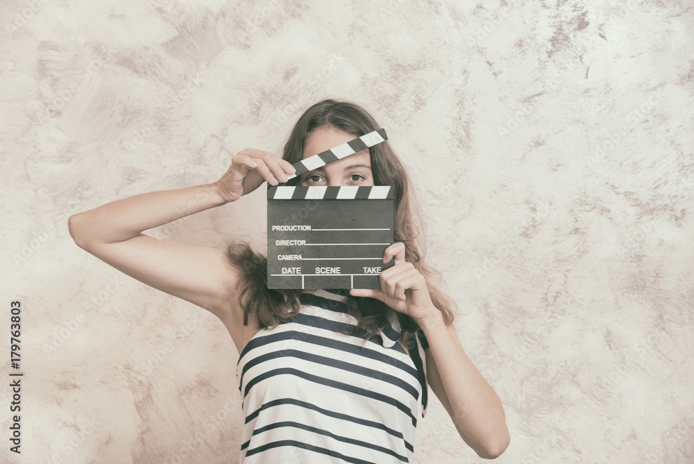 Fototapeta premium Woman with movie clapper board over face audition concept