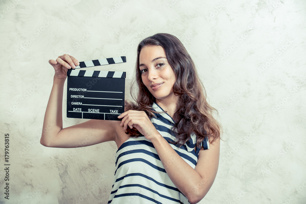 Obraz premium Woman smiling with clapper board movie audition concept