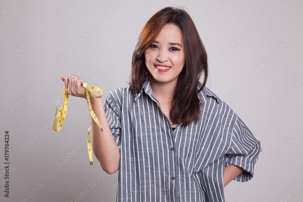 Young Asian woman with measuring tape. Young Asian woman with measuring tape.