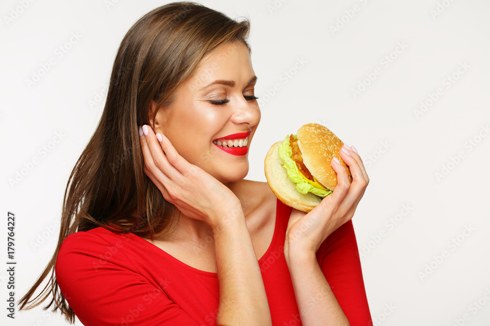 Smiling woman wearing red dress holding big burger. Smiling woman wearing red dress holding big burger.