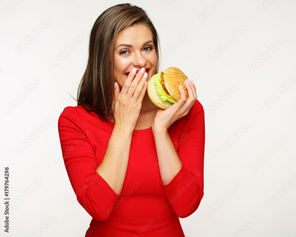 Woman holding big burger embarrassed.