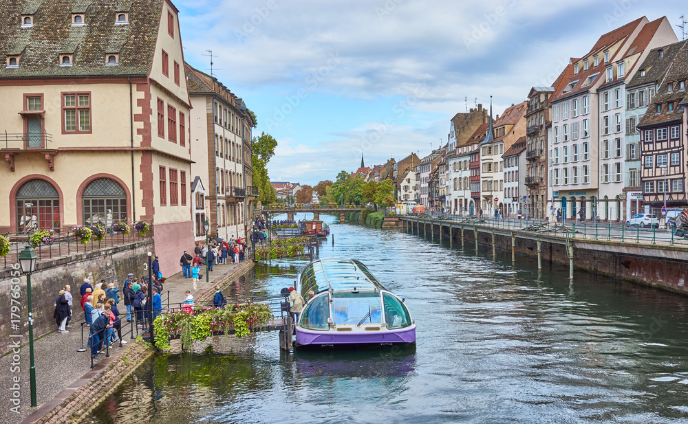 Tourist Boat on river in beautiful downtown of Strasbourg / Housing and river in city of Strasbourg in Alsace France