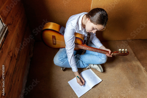 girl with a guitar who writes a song photo