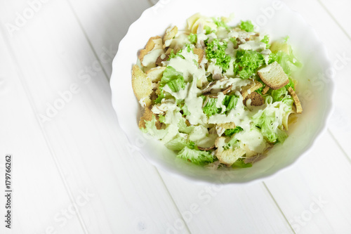 Mixed salad with green apple and walnuts on the table