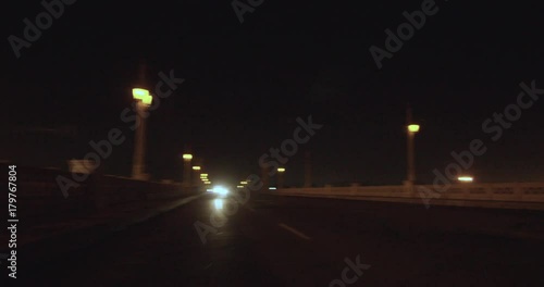 Slow motion, motorcycle pops wheelie on bridge