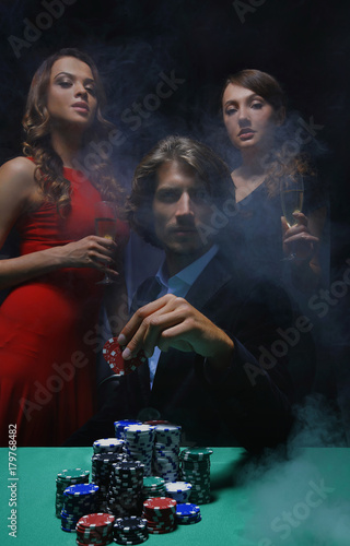 fortunate gambler surrounded by seductive elegant women