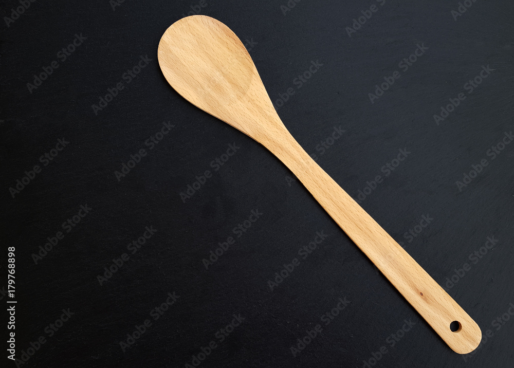 Wooden spoon over textured dark background Wooden spoon over textured dark background
