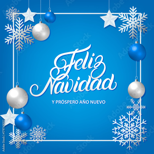 Feliz Navidad hand written lettering with silver decoration ornament.