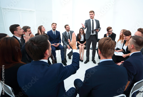 skilled coach asks questions to the participants of the training.