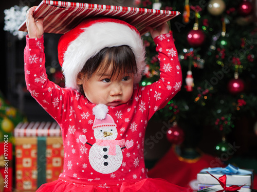 Santa baby girl opening her Christmas gift