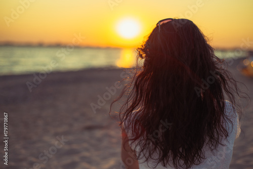 Brunette girl on the background of the sea sunset