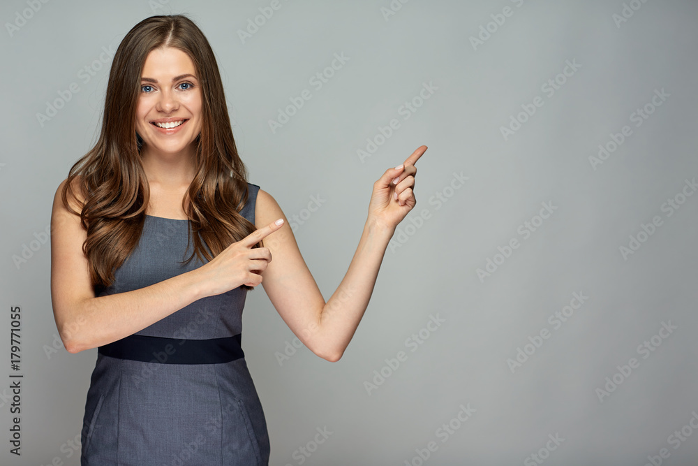 Smiling business woman pointing finger at gray Smiling business woman pointing finger at gray