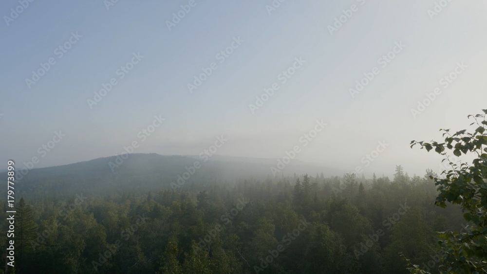 Bird's-eye view of a scenic sunset over the forest hills. Summer mountain landscape. Tourist tents near forest