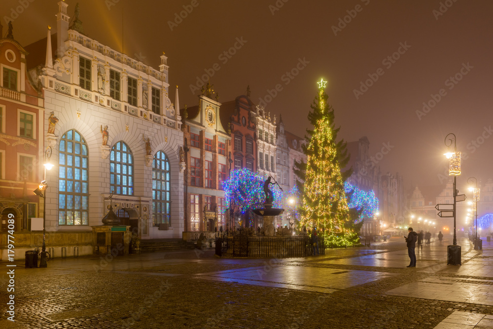 Historical Artus Court, fountain of the Neptune and Christmas tree in the centre of Gdańsk. Foggy night. Poland
