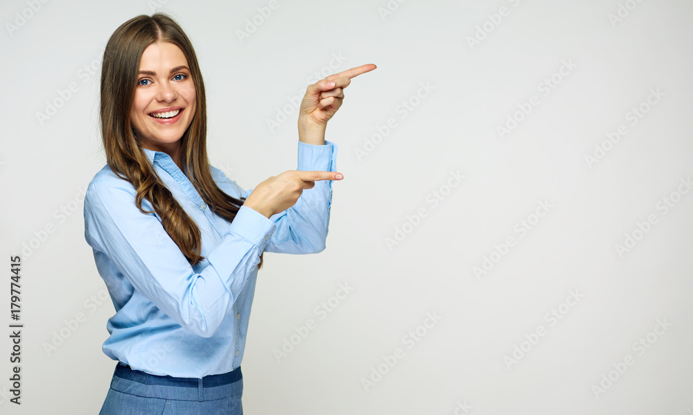 Smiling business woman pointing finger at copy space.