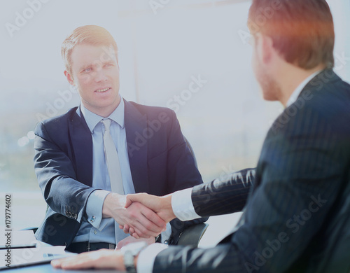 Wallpaper Mural Business colleagues sitting at a table during a meeting with two male executives shaking hands Torontodigital.ca